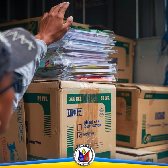 Mga kahon ng school supplies na may laman na notebook, inaayos para sa pamamahagi sa mga mag-aaral ng Naic