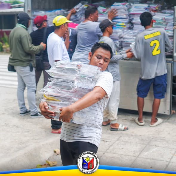 Mga tauhan na nagbubuhat at nag-aayos ng mga school supplies mula sa trak para sa pamamahagi sa mga paaralan