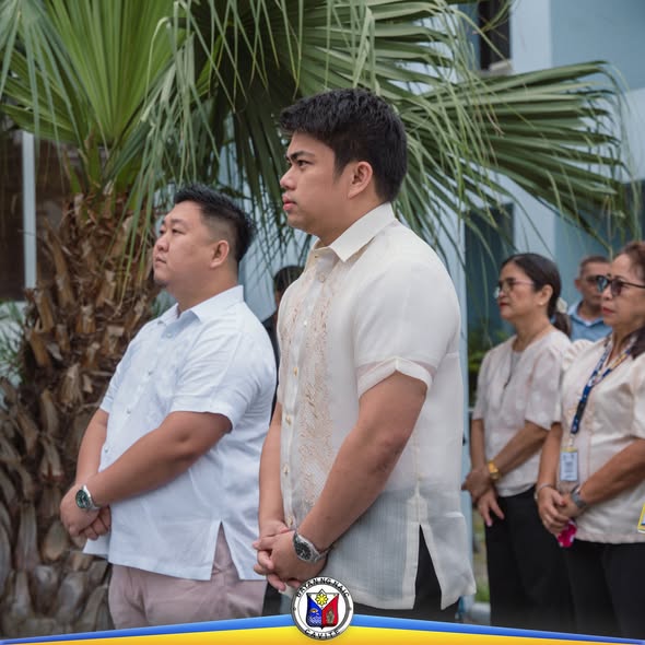 Mga kawani at opisyal na nakatayo nang maayos sa flag raising ceremony sa Naic Municipal Hall