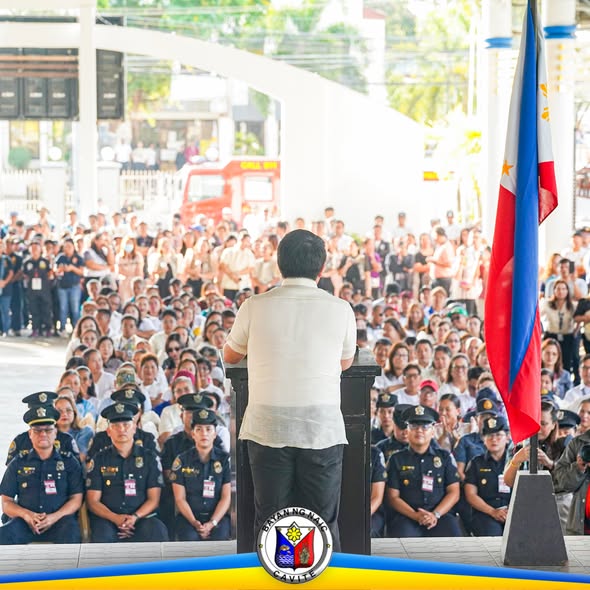 Flag raising ceremony sa Naic Town Plaza, may nagsasalita sa podium at maraming dumalo kasama ang mga pulis