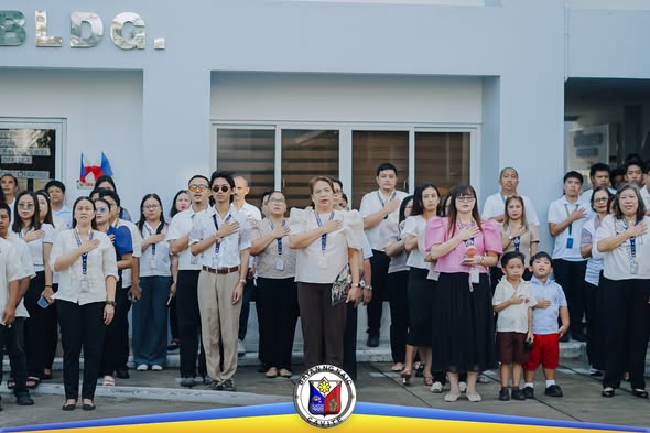 Mga kawani ng LGU habang nagbibigay-galang sa flag raising ceremony sa harap ng gusali sa Naic Municipal Grounds