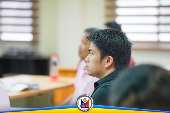 Litrato: Isang lalaki na nakikinig sa pulong ng Naic Municipal Project Monitoring Committee sa ABC Hall
