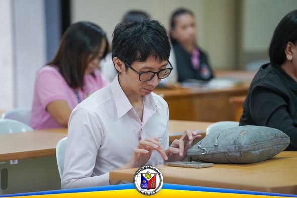 Lalaking gumagamit ng tablet sa pulong ng Naic Municipal Project Monitoring Committee sa ABC Hall
