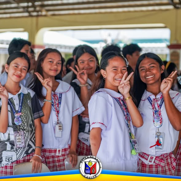 Mga estudyanteng nakangiti at nagpapakita ng peace sign sa covered area ng HabiKuna culminating activity sa Naic