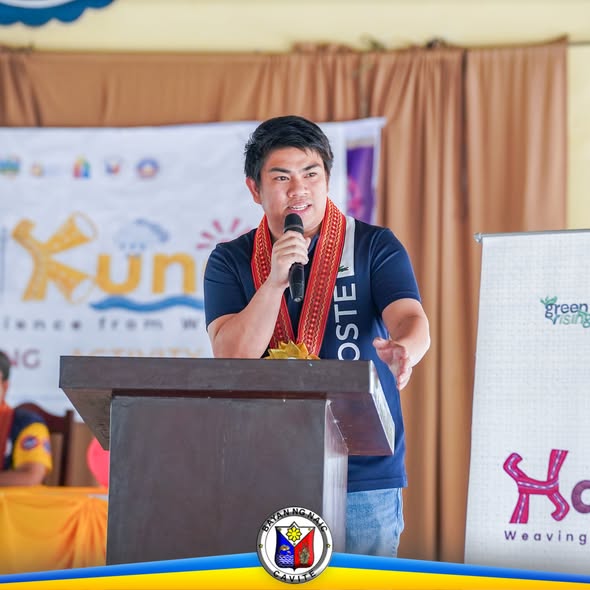 Nagsasalita sa podium ang isang lalaki sa HabiKuna: Weaving Resilience from Waste, Culminating Activity sa Naic