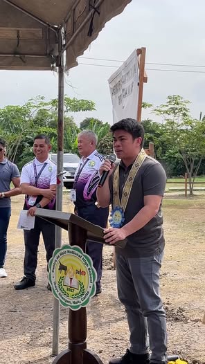 Isang opisyal na nagsasalita sa mikropono sa groundbreaking ng school building sa Centro De Naic National Highschool
