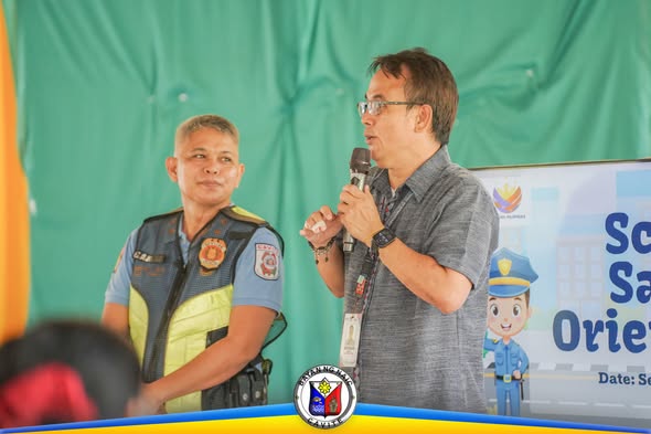 Tagapagsalita sa School Safety Orientation katabi ang pulis sa Naic Elementary School