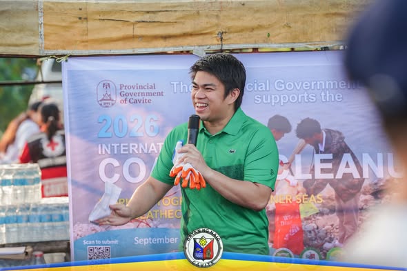 Nagsasalita sa mikropono ang isang lider sa coastal cleanup activity sa Barangay Timalan Concepcion, Naic