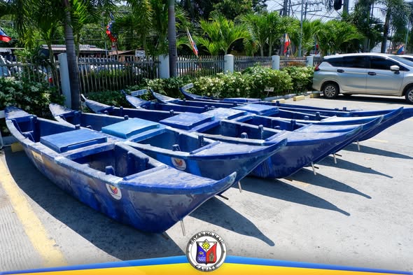 Mga bagong asul na bangka para sa mga mangingisda ng Naic, nakahanay sa paradahan