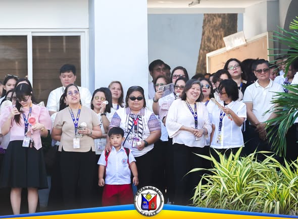 Mga kawani ng Naic Municipal Hall na nagtipon sa Flag Raising Ceremony, kasama ang batang naka-uniporme sa harap