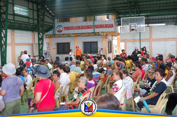 Mga senior citizen na nakaupo sa covered court ng Brgy. Bagong Karsada habang naghihintay ng Social Pension payout