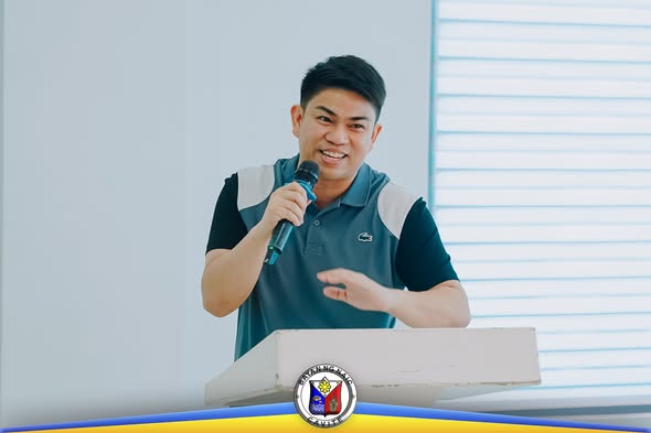 Lalaking nagsasalita gamit ang mikropono sa podium sa loob ng silid ng pagpupulong, League of Assessors of Cavite