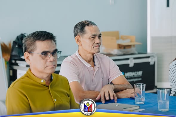 Dalawang lalaking nakaupo sa mesa habang nakikinig sa pagtitipon ng League of Assessors sa Naic, Cavite