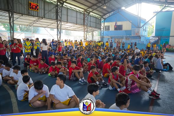 Mga kabataan na nakaupo sa covered court habang nagaganap ang Municipal Sports Meet 2026 sa Naic