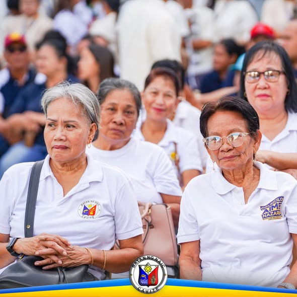 Mga matatandang kalahok na naka-puting polo habang nakikinig sa Flag Raising Ceremony sa Naic, Cavite