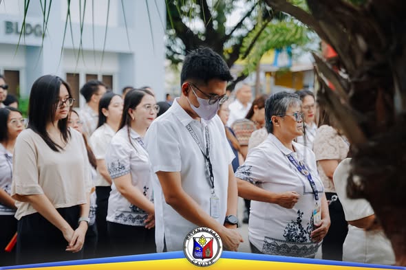Mga kawani ng lokal na pamahalaan na nakayuko habang nagdarasal sa Flag Raising Ceremony sa Naic