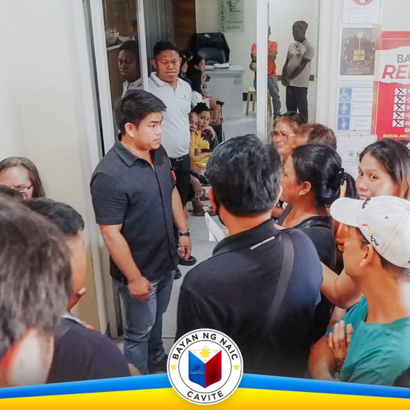 Dagsa ng mga residente sa loob ng Municipal Hall habang may kausap na opisyal sa pasilyo