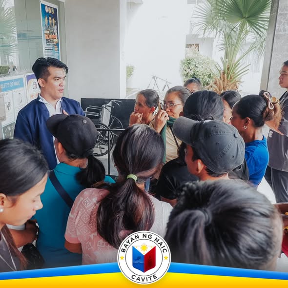 Mga residente na nagtitipon sa pasukan ng Municipal Hall ng Naic habang may kausap na opisyal