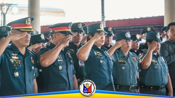 Mga uniporme na tauhan na nagsasaludo sa seremonya sa labas ng gusali, bahagi ng flag-raising ceremony sa Naic