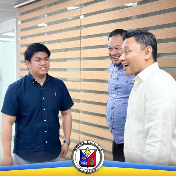 Tatlong lalaki na nag-uusap at nakangiti sa loob ng opisina sa harap ng kahoy na dingding, Naic, Cavite