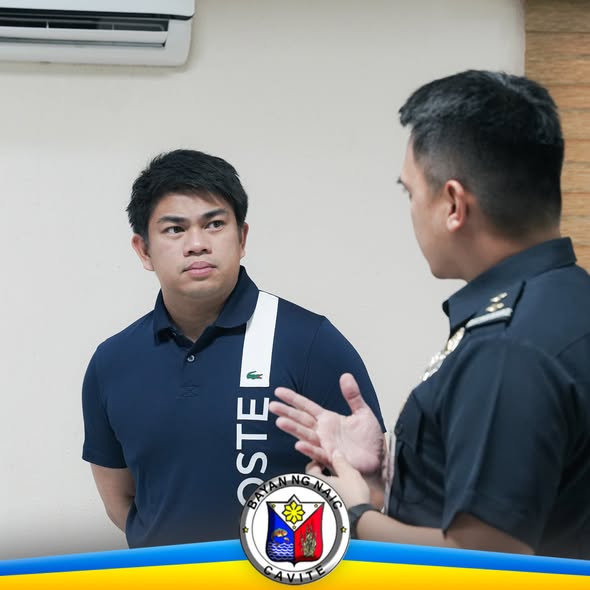 Dalawang lalaki nag-uusap sa loob ng opisina, may logo ng Bayan ng Naic sa ibaba