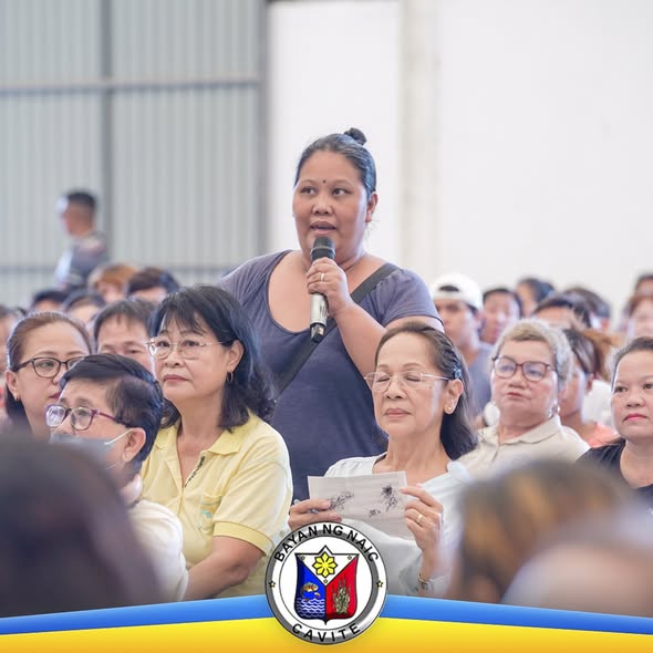Babaeng nagsasalita sa mikropono habang nakikinig ang mga dumalo sa pagpupulong ng mga vendors sa palengke