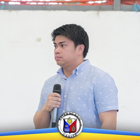 Lalaking nagsasalita gamit ang mikropono sa pagpupulong ng mga public market vendors sa Naic