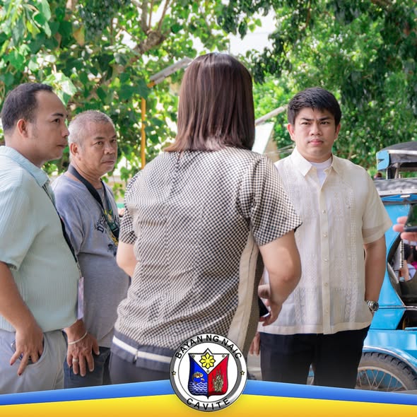 Mga opisyal at kawani ng Naic na nag-uusap sa labas malapit sa tricycle habang bumibisita sa konstruksyon