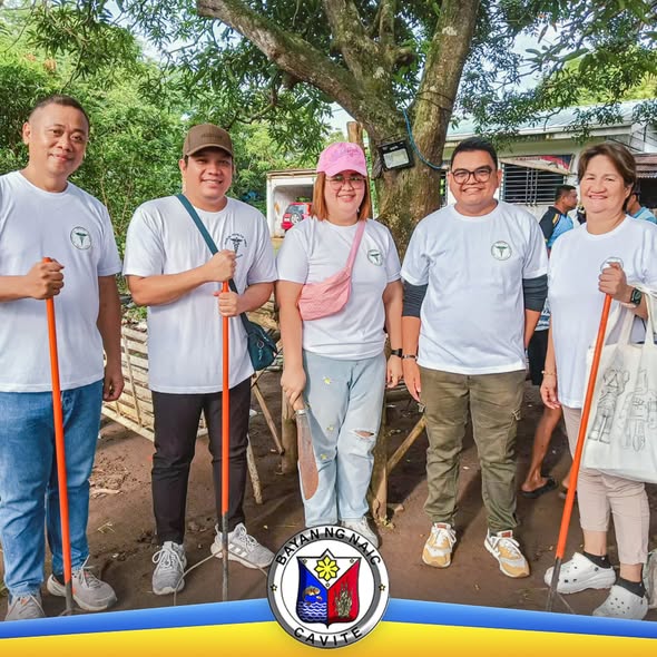 Mga boluntaryo na may dalang walis at kalaykay habang nagl-linis sa subdivision para sa dengue awareness