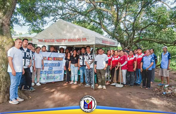 Grupo ng mga volunteer sa ilalim ng tent habang nagsasagawa ng Search and Destroy Dengue clean-up drive