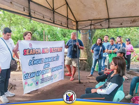 Grupo habang hawak ang banner ng Search and Destroy Dengue Awareness and Clean up Drive sa ilalim ng shelter