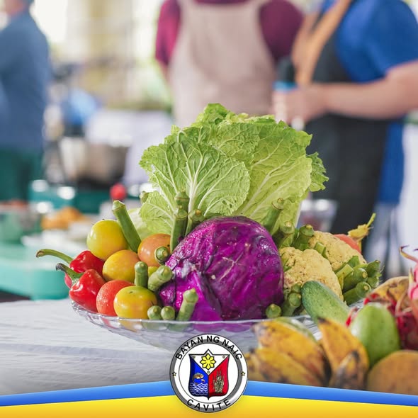 Sariwang gulay at prutas sa palanggana, may mga taong nasa likuran sa Nutrition Month launching sa Naic