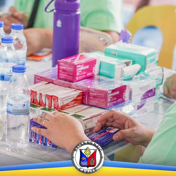 Mga gamot at bote ng tubig na inaayos sa mesa sa libreng serbisyong medikal sa Naic Covered Court