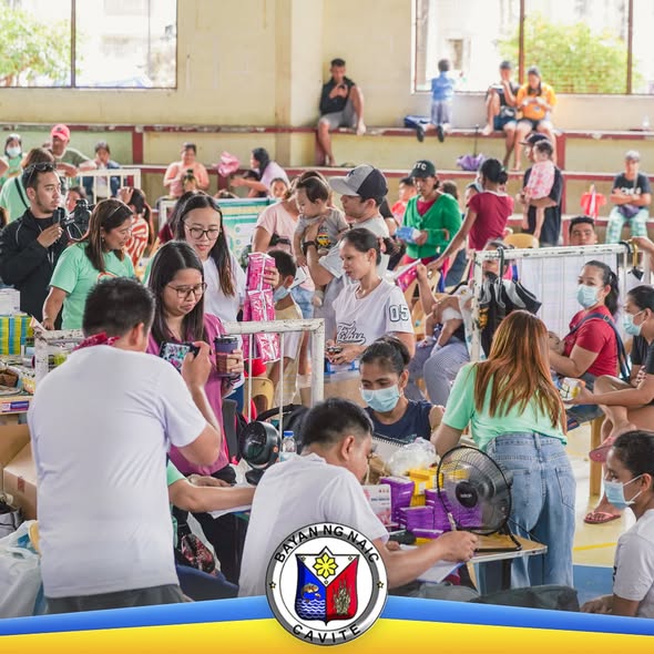 Mga tao sa covered court habang pumipila at tumatanggap ng libreng serbisyong medikal sa Naic