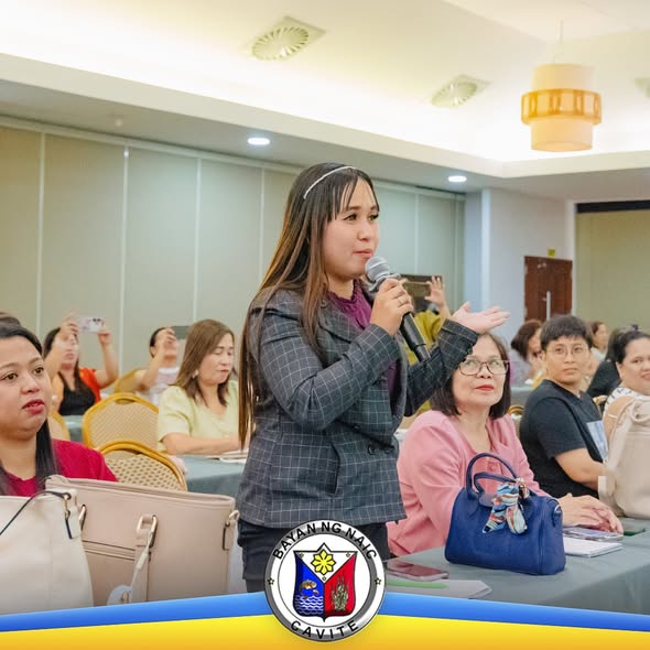 Isang babae na may mikropono habang nagsasalita sa seminar para sa mga guro ng daycare sa Naic