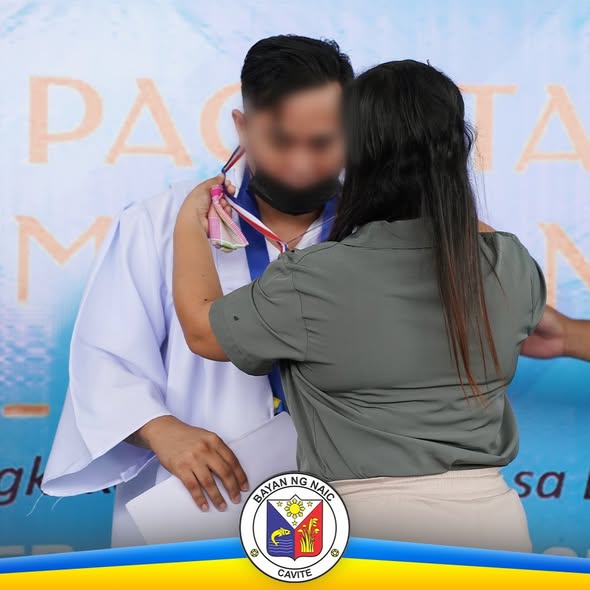 Pagsasabit ng medalya sa isang nagtapos sa seremonya ng pag-aangat sa Naic Municipal Jail