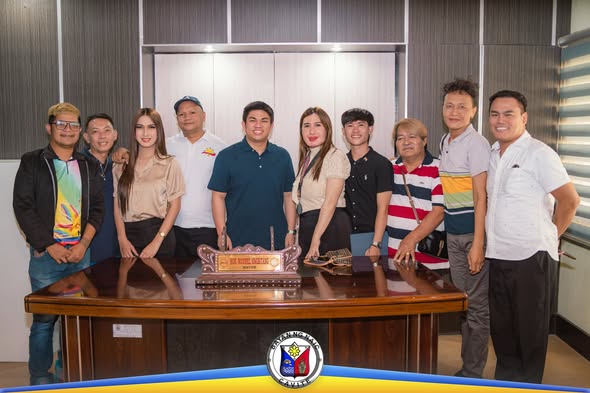 Grupo ng mga tao na nagpose sa opisina sa likod ng mahabang mesa na may plaque, Naic, Cavite