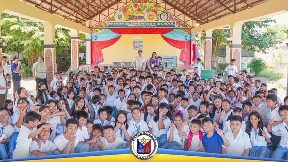 Mga mag-aaral ng Muzon Elementary School na nagpose sa harap ng entablado sa covered court