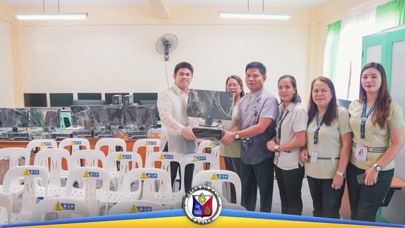 Pagkakamay sa silid-aralan na may mga desktop computer at upuan, para sa pamamahagi ng kagamitan sa paaralan