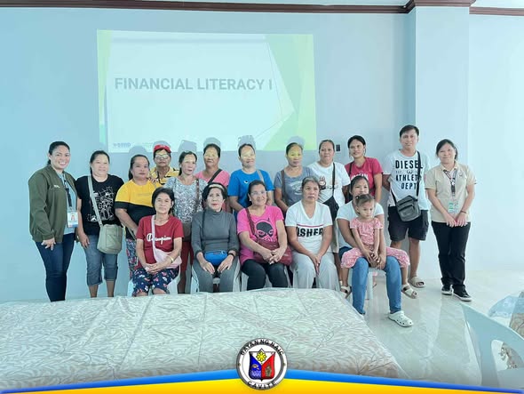 Grupo ng mga kalahok sa Financial Literacy seminar habang nagpapose sa harap ng screen na may pamagat na Financial Literacy I