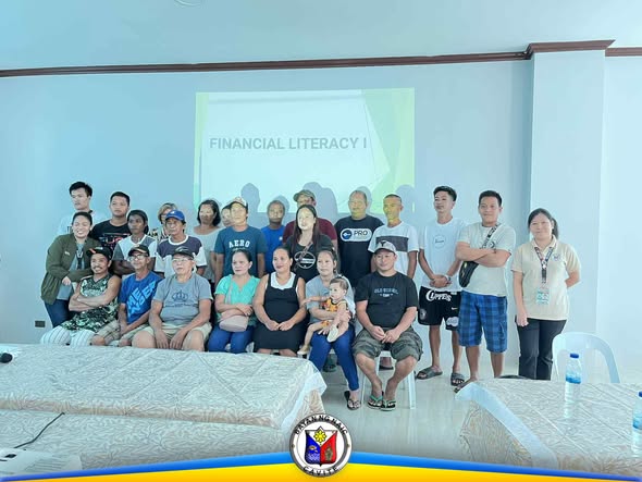 Grupo ng mga kalahok sa Financial Literacy seminar sa harap ng screen na may nakasulat na 'Financial Literacy I'