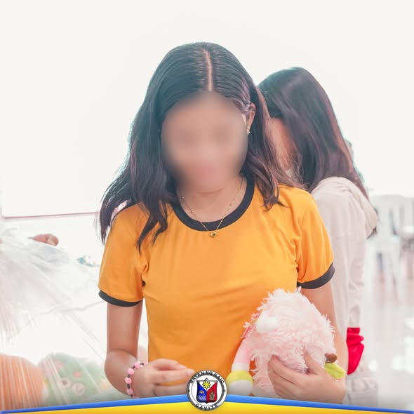 Batang babae na may hawak na pink na laruan habang nakikilahok sa Girl Child Week Celebration 2025 sa Naic