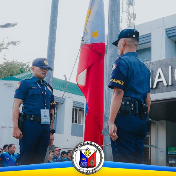 Mga uniformed na pulis habang nagsasagawa ng flag raising ceremony sa harap ng Municipal Hall ng Naic