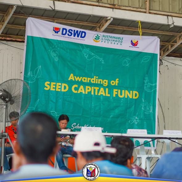 Pamamahagi ng Seed Capital Fund sa ilalim ng SLP ng DSWD sa Naic, may banner at mga tatanggap sa harap