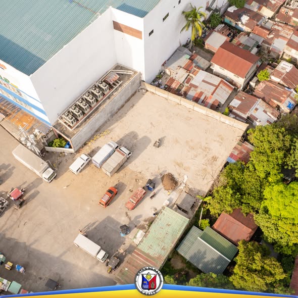 Aerial na larawan ng lote sa tabi ng Naic Public Market, may mga nakaparadang trak at sasakyan