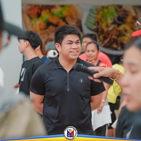 Lalaki na naka-itim na polo habang nagsasalita sa mikropono sa isang bloodletting activity sa Naic