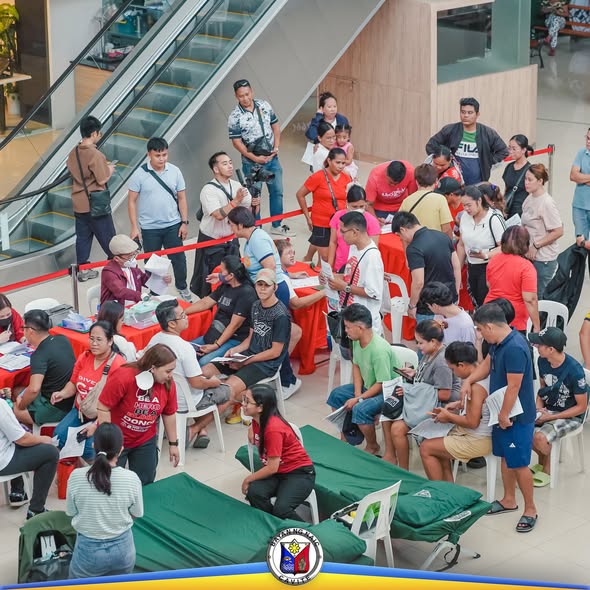 Mga tao habang nagbi-bloodletting sa atrium ng mall, may mga staff sa mesa at nakahilera ang mga cot at upuan