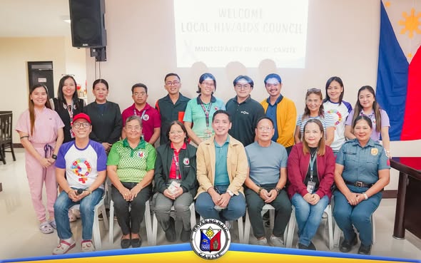 Grupo ng mga kalahok sa pulong ng Local AIDS Council sa Naic, Cavite, nagpose sa harap ng screen