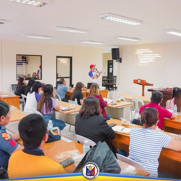 Pulong ng Local AIDS Council sa Liga ng Barangay, may nagsasalita sa harap habang nakikinig ang mga dumalo