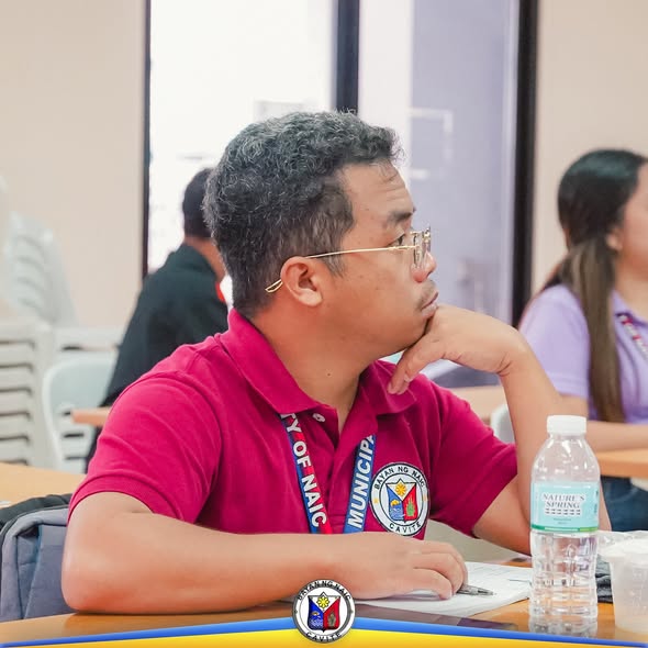 Lalaking naka-pulang polo habang nakikinig sa pulong ng Local AIDS Council sa Naic